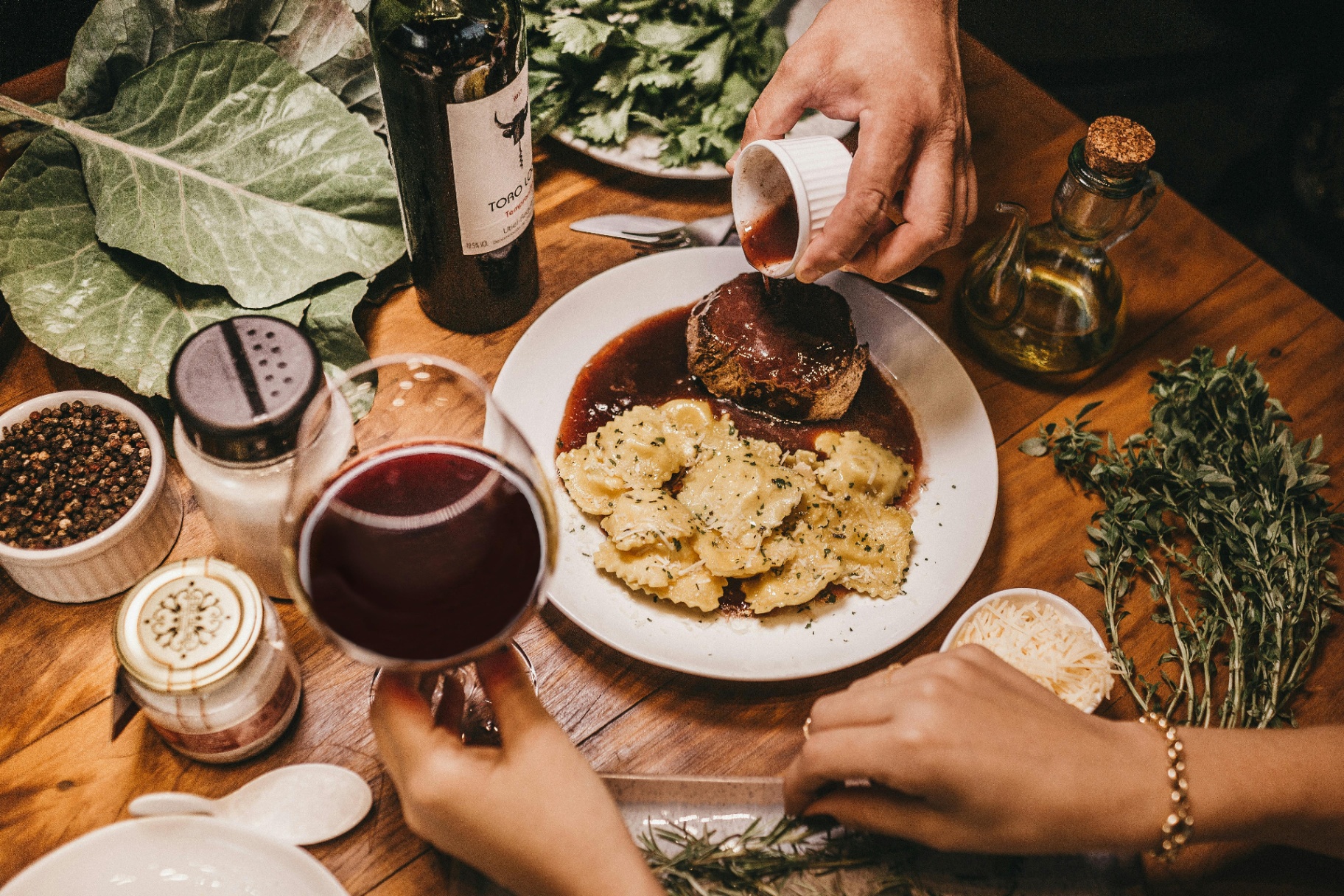A meal thoughtfully plated with fresh herbs and wine